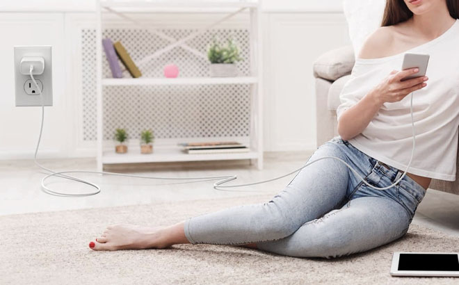 A Woman Holding a Phone While Charging