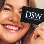 A Woman holding a DSW Card