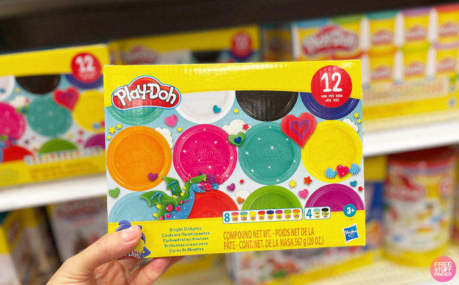 A person holding a box of Play Doh Bright Delights 12 Pack