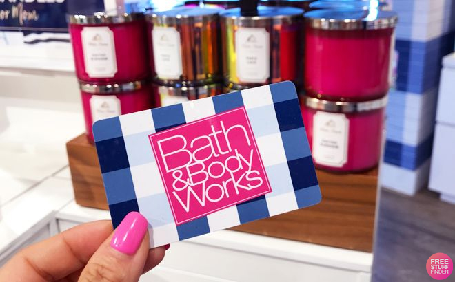 Bath Body Works Gift Card Being Held in front of some candles