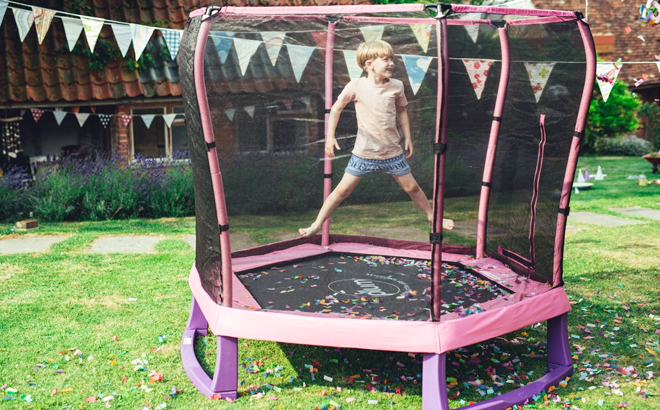Boy Jumping in the Plum Play Junior 7 Foot Trampoline with Safety Enclosure