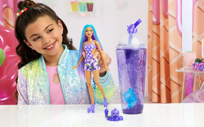 Girl is Playing with Barbie Pop Reveal Fruit Series Grape Fizz Doll