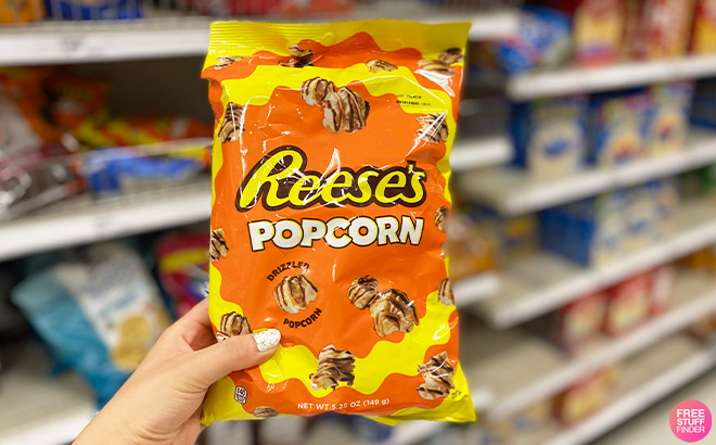 Hand Holding Reeses Popcorn Bag