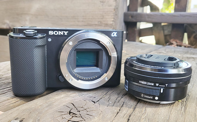 Sony Alpha ZV E10 Kit Mirrorless Vlog Camera next to Lens on a Wooden Tabletop