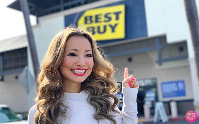 Tina in Front of Best Buy Pointing at the Best Buy Storefront Sign