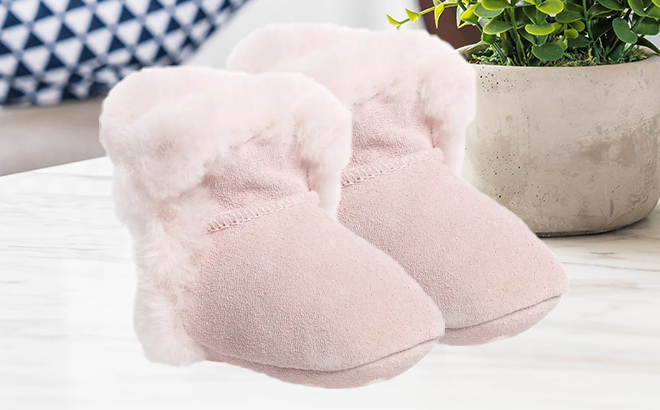 UGG Lassen Genuine Shearling Crib Shoes in Pink on a Counter