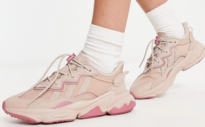 Woman is Wearing Adidas Originals Ozweego Sneakers in Beige and Pink Color