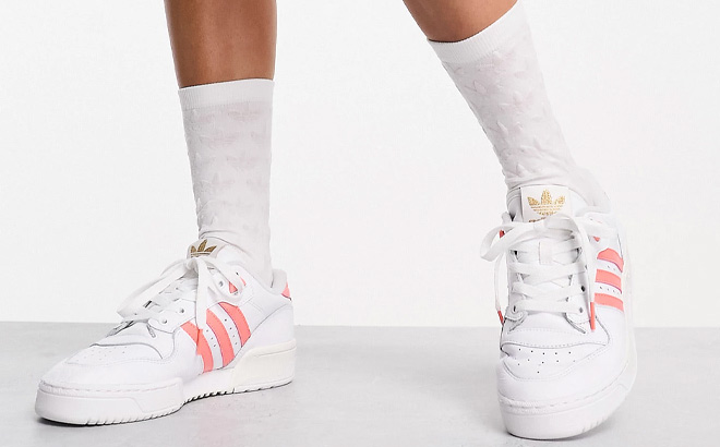 Woman is Wearing Adidas Originals Rivalry Low Sneakers in White and Coral Color