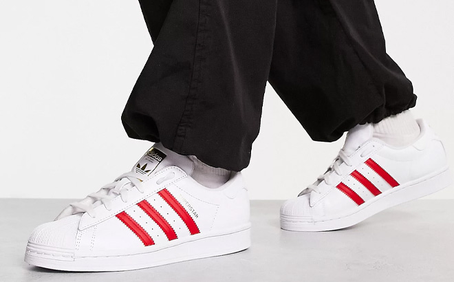 Woman is Wearing Adidas Originals Superstar Sneakers in White and Plum Color