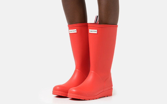 Woman is Wearing Hunter Play Tall Boots in Red Color