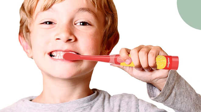 a kid brushing his teeth using the Colgate Battery Powered Toothbrush