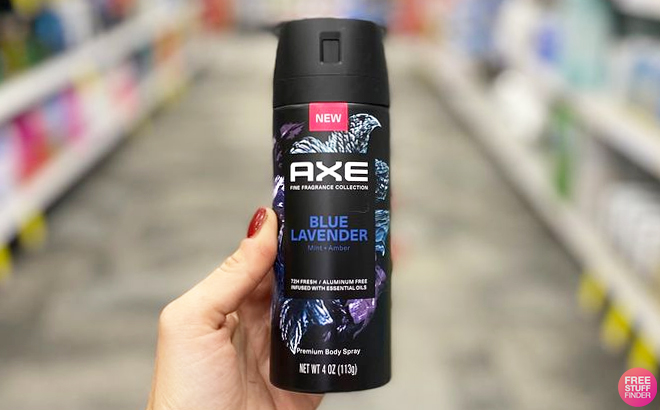 A Hand Holding Axe Fine Fragrance Body Spray in CVS Store