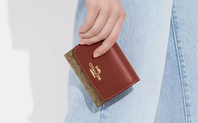 A Hand Holding Coach Outlet Small Trifold Wallet