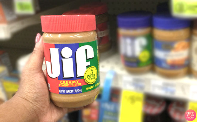 A Hand Holding Jif Creamy Peanut Butter 16 oz