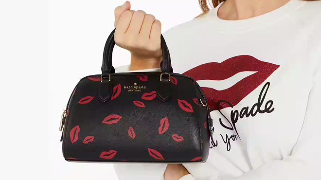 A Person Holding Kate Spade Madison Lip Toss Duffle Crossbody