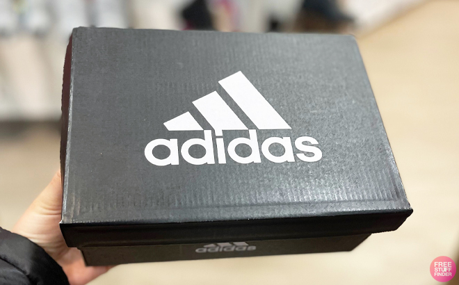 A Person Holding a box of Adidas