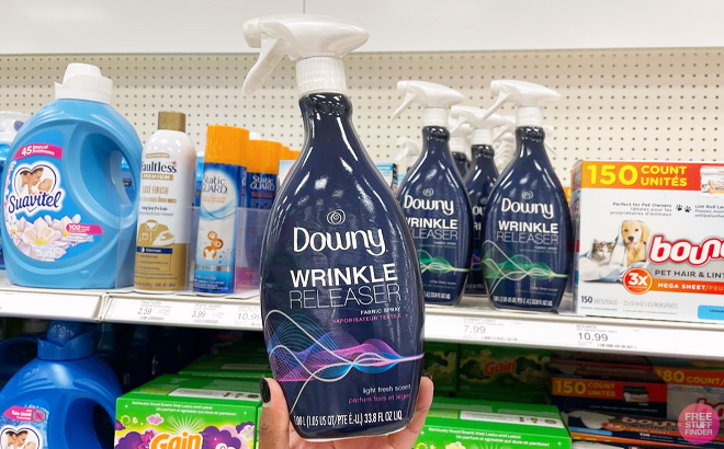 A Person holding the Downy Wrinkle Releaser Light Fresh Scent Fabric Refresher Spray