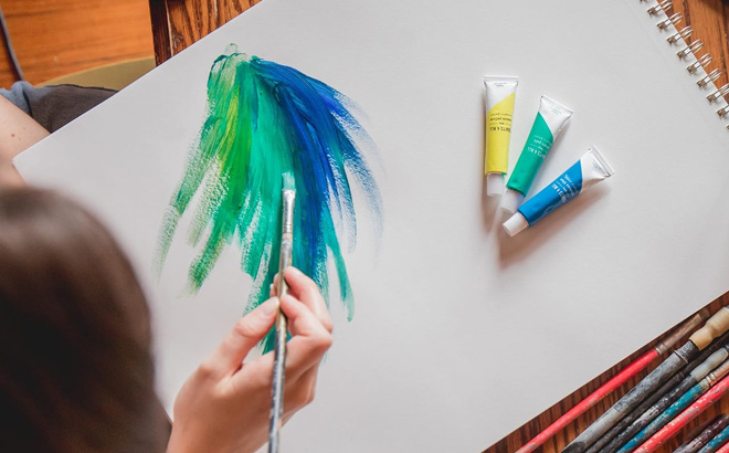 Hand Holding Art Brush from Acrylic Paint Set
