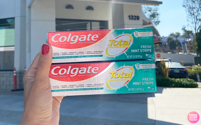 Hand Holding Colgate Total Fresh Mint Stripe in Front of the Walgreens Store