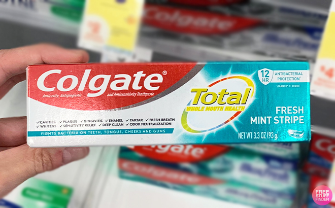 Hand Holding Colgate Total Fresh Mint Stripe in the Walgreens Store