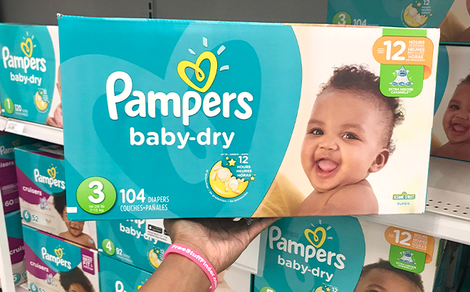 Hand Holding Pampers Baby Dry Diapers 104 Count