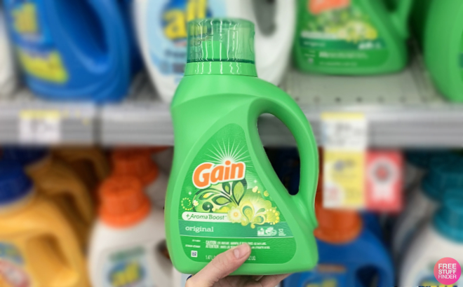 Hand Holding a Gain Aroma Boost Liquid Laundry Detergent