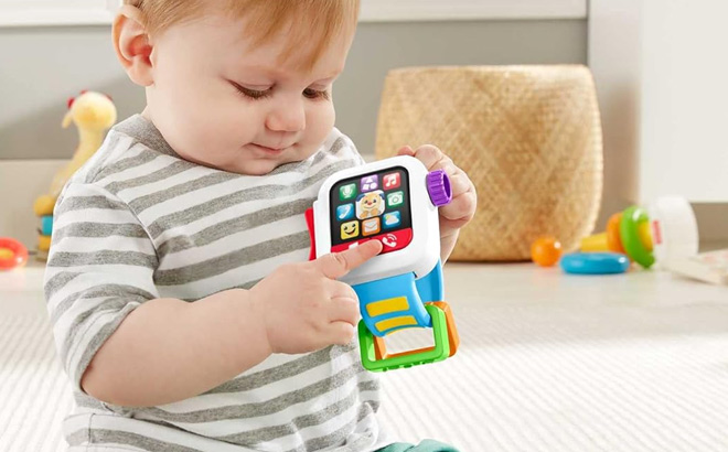 Kid is Holding Fisher Price Laugh Learn Baby To Toddler Toy Time To Learn Smartwatch