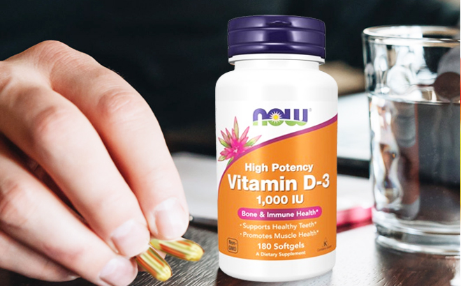 NOW Supplements Vitamin D 3 1 000 IU on the table with a person holding softgels