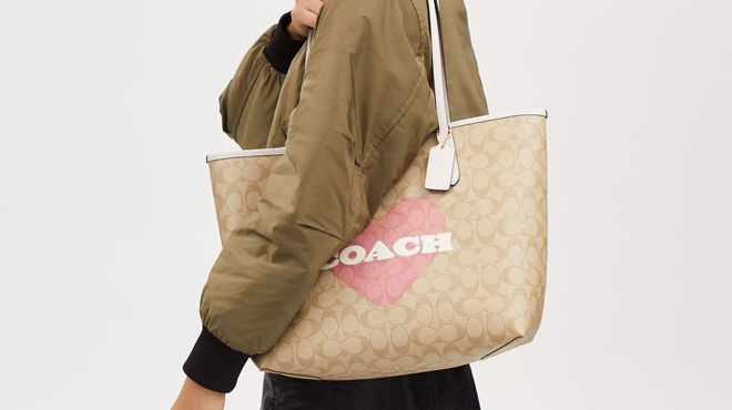 Person Carrying a Coach Outlet City Tote In Signature Canvas