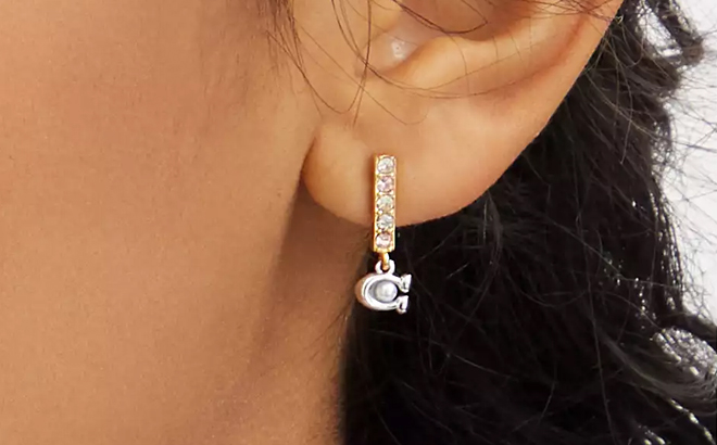 Person Wearing Coach Outlet Signature Pave Bar Huggie Earrings