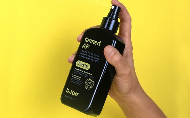 Person holding the B Tan Intensifier Tanning Oil