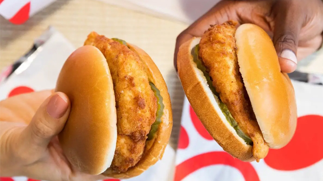 Two People Holding a Chick fil A Chicken Sandwich
