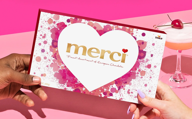Two people holding the Merci Finest Valentines Day Assorted Chocolate Candy Gift Box