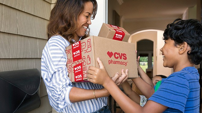 Woman and Child Holding a CVS Delivery Box on the Front Porch