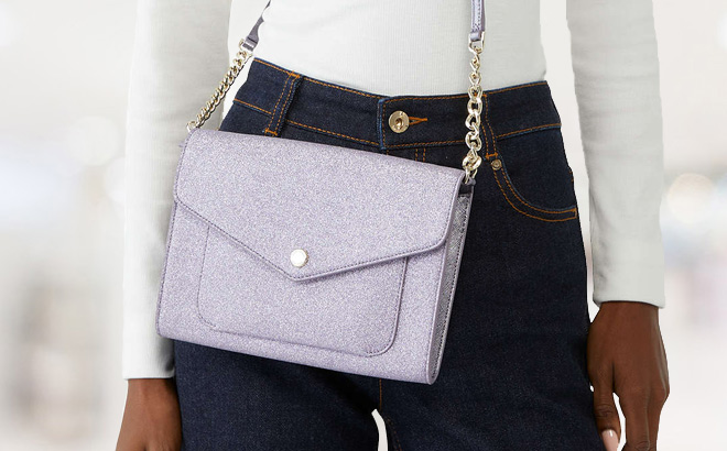Woman is Wearing Kate Spade Tinsel Flap Crossbody in Lilac Frost Color