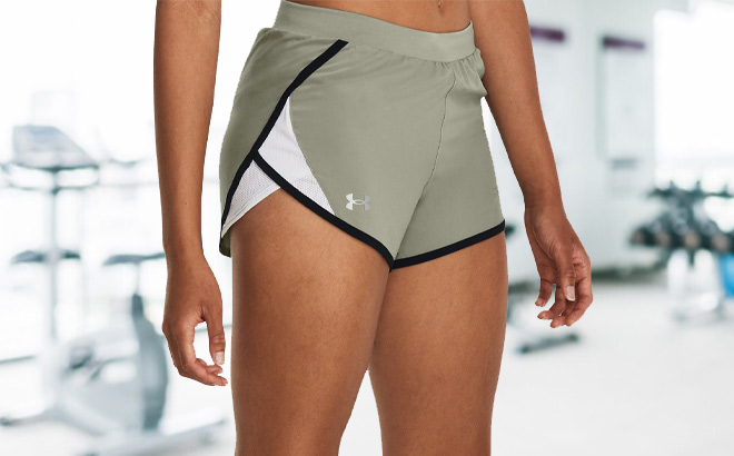 Woman is Wearing Under Armour Fly By 2 0 Shorts in Grove Green Color
