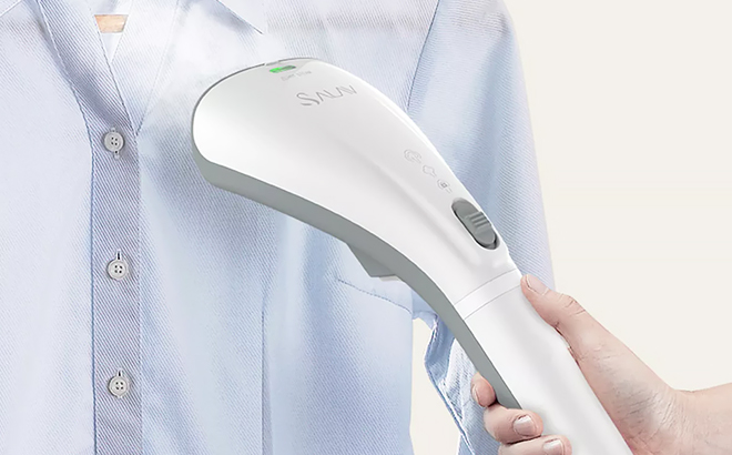 A Hand Holding Quicksteam Handheld Garment Steamer in White Color