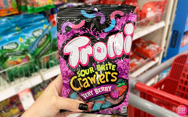 A Hand Holding a Pack of Trolli Sour Brite Crawlers Very Berry Gummy Worms