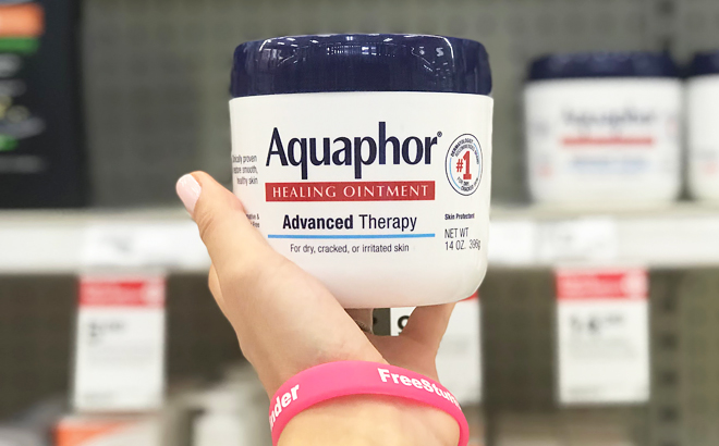 A Hand Holding an Aquaphor Healing Ointment Jar