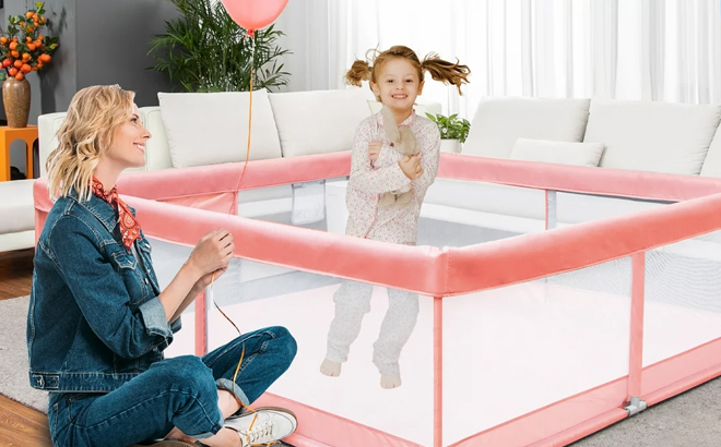 A Kid Playing Inside a Baby Playpen in Pink Color