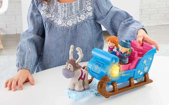 A Little Girl Playing with the Fisher Price Little People Disney Frozen Sleigh Vehicle with Figures Set