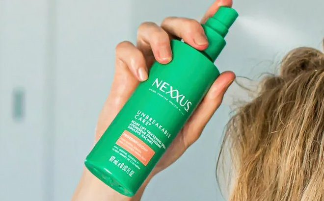 A Person Holding Nexxus Unbreakable Care Root Lift Hair Thickening Spray