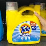 A Person Holding Tide Simply Liquid Laundry Detergent on a Shelf at a Store
