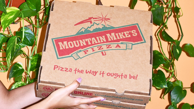 A Person Holding Two Boxes of Mountain Mikes Pizza