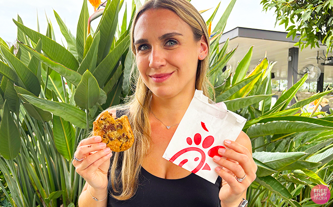 A Person Holding a Chick Fil A Chocolate Chunk Cookie with Greenery in the Background