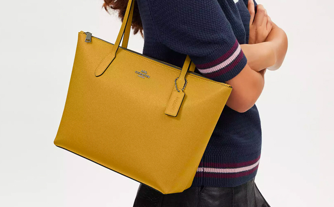 A Person Wearing Yellow Coach Tote Bag