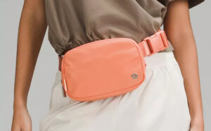 A Person Wearing a Lululemon Everywhere Belt Bag 1L in the Color Coral Kiss