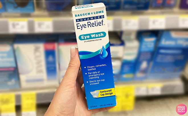 A Person is Holding Advanced Eye Relief Bausch Lomb Eye Wash in a Store Aisle