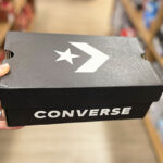 A Person is Holding a Box With Converse Shoes