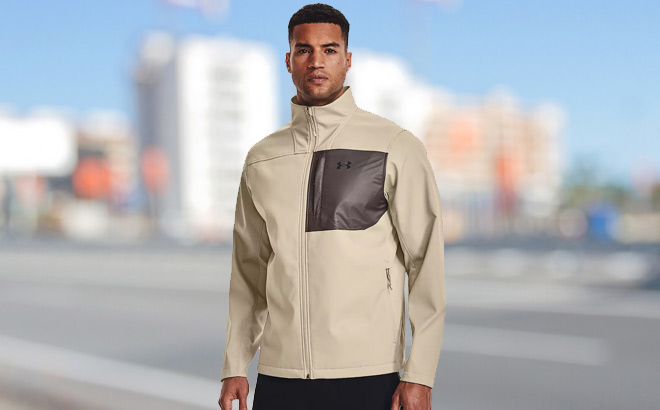 A Person is Wearing Under Armour ColdGear Infrared Shield Softshell Jacket in City Khaki Color